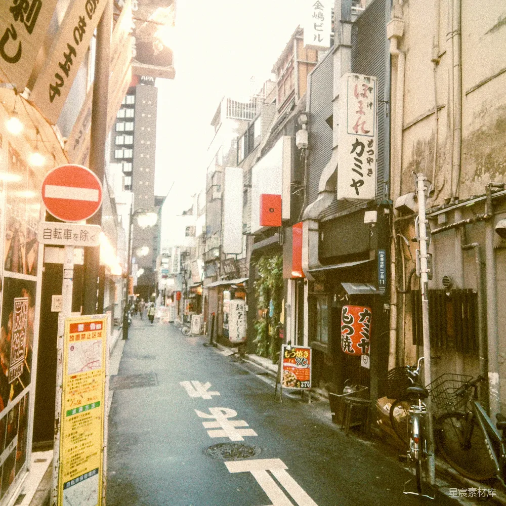 高清摄影  一条狭窄的城市街道，两旁排列着建筑物和标志牌。