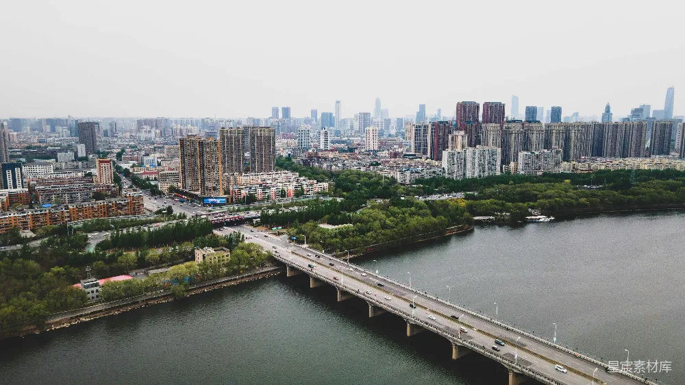 高清摄影  一座横跨河流的桥，背景是一座城市。