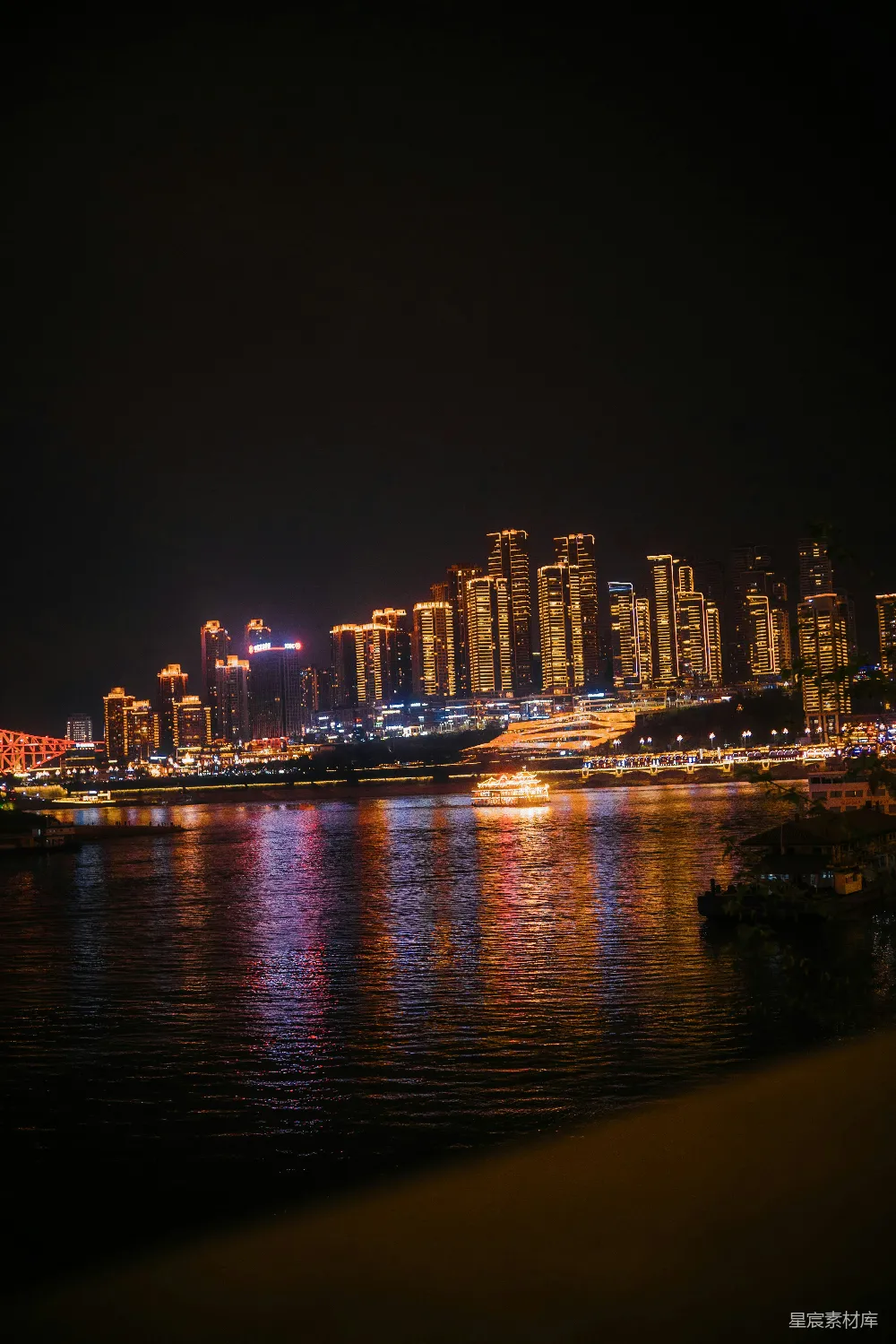 高清摄影  城市的天际线在夜间被点亮，倒映在河面上。