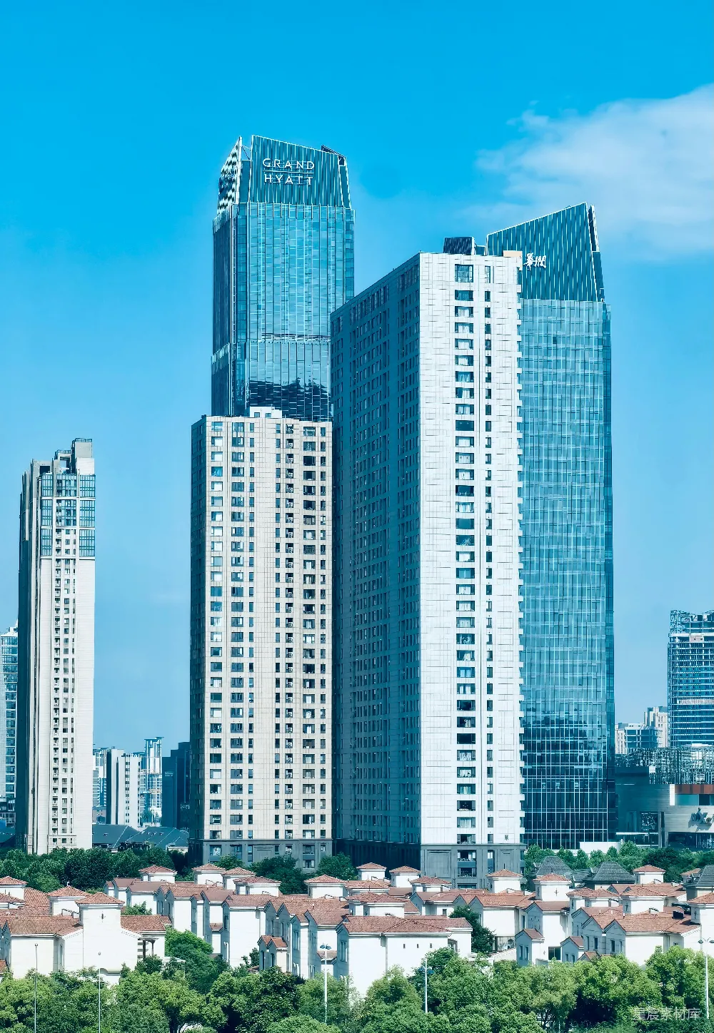 高清摄影  现代摩天大楼在晴朗的蓝天中高耸，矗立在郊区住宅之上。