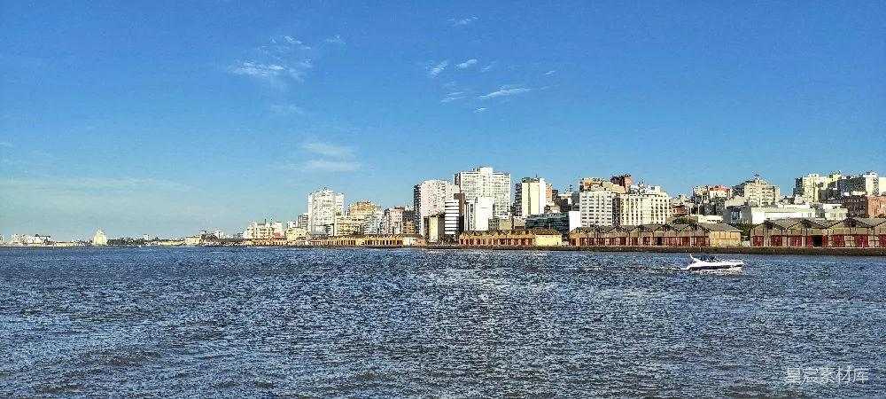 高清摄影  一条船沿着河边的城市逆流而行