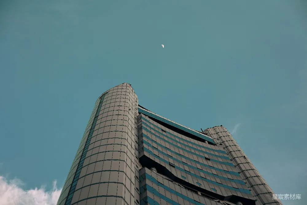 高清摄影  一座高楼，天空中挂着一轮弯月。