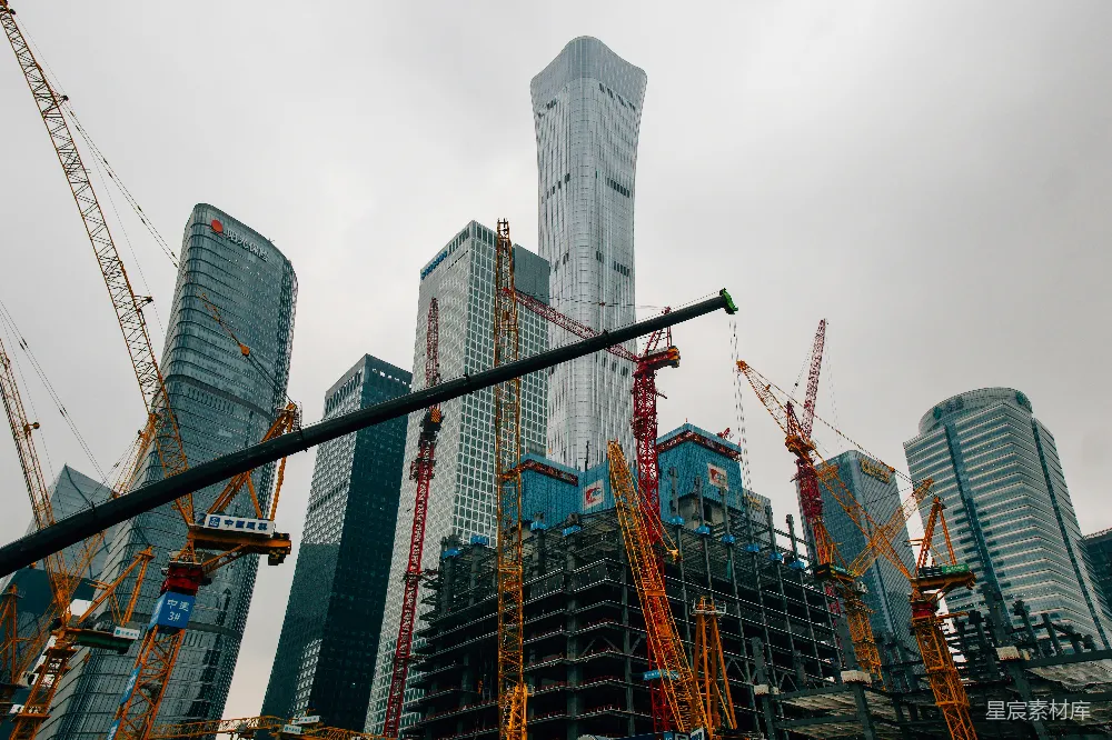 高清摄影  一群高大的起重机站在一幢高楼前面。