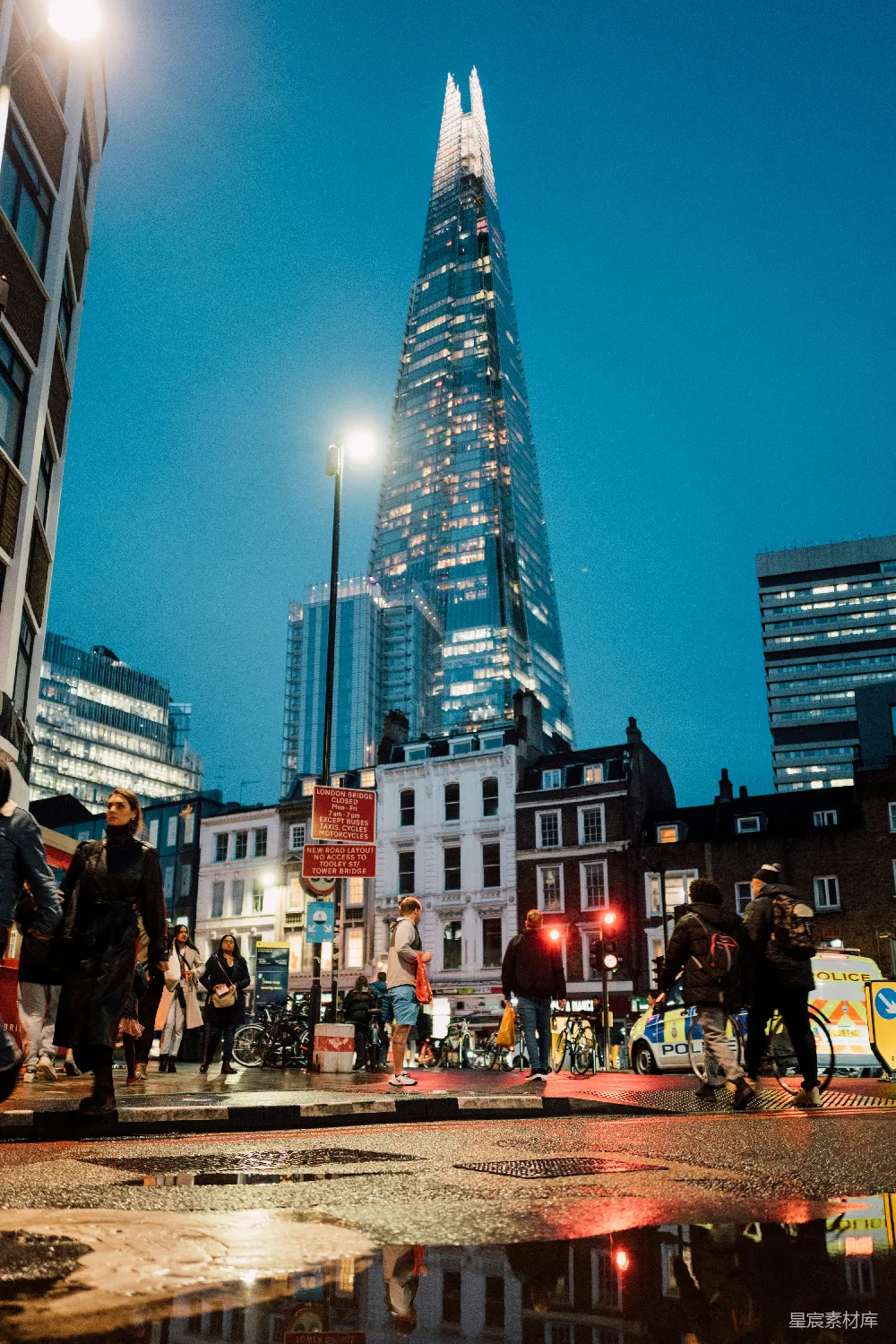高清摄影  一群人正穿过一栋高楼前的街道。