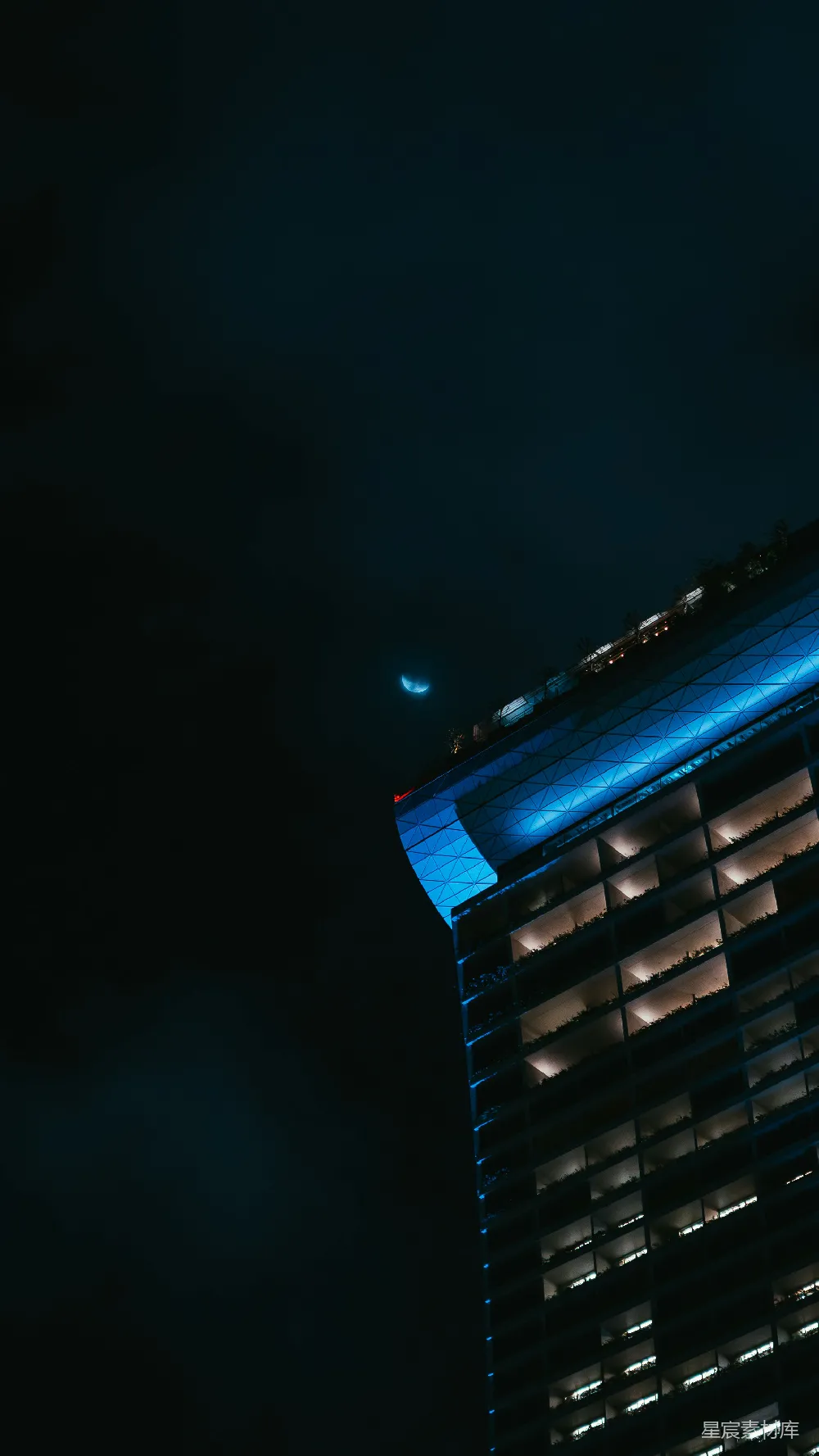 高清摄影 壁纸 夜晚的建筑物在月光下显得格外明亮，挂着一轮新月。