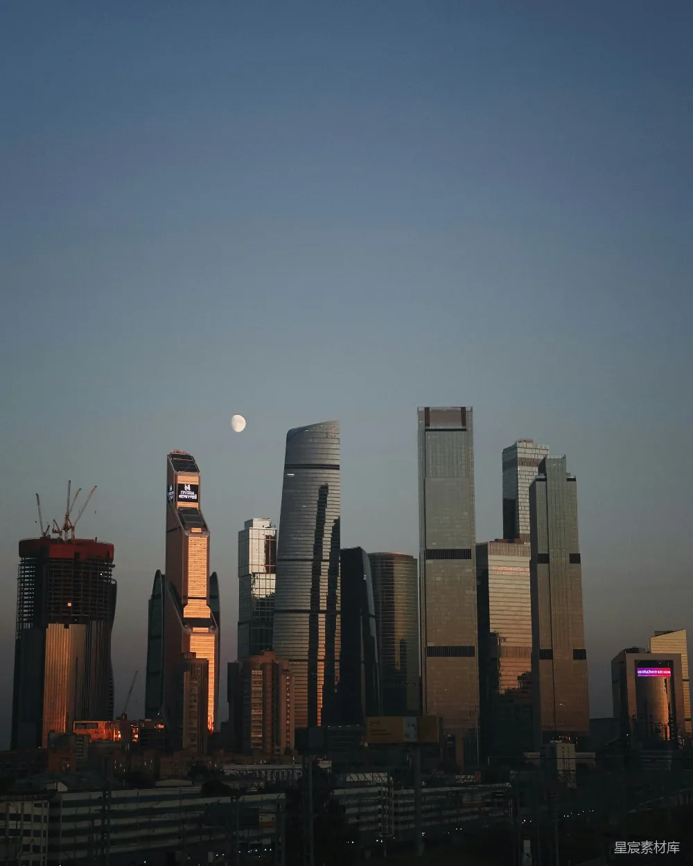 高清摄影  城市天际线，摩天大楼林立，天空中挂着一轮满月。