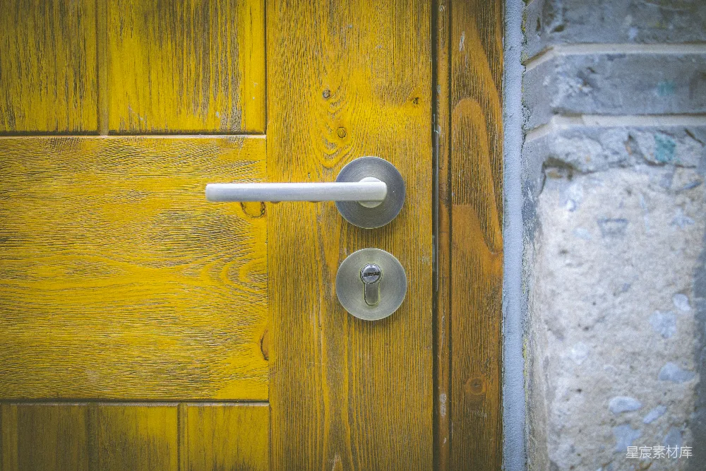 高清摄影  一扇黄色的门，门把是白色的。