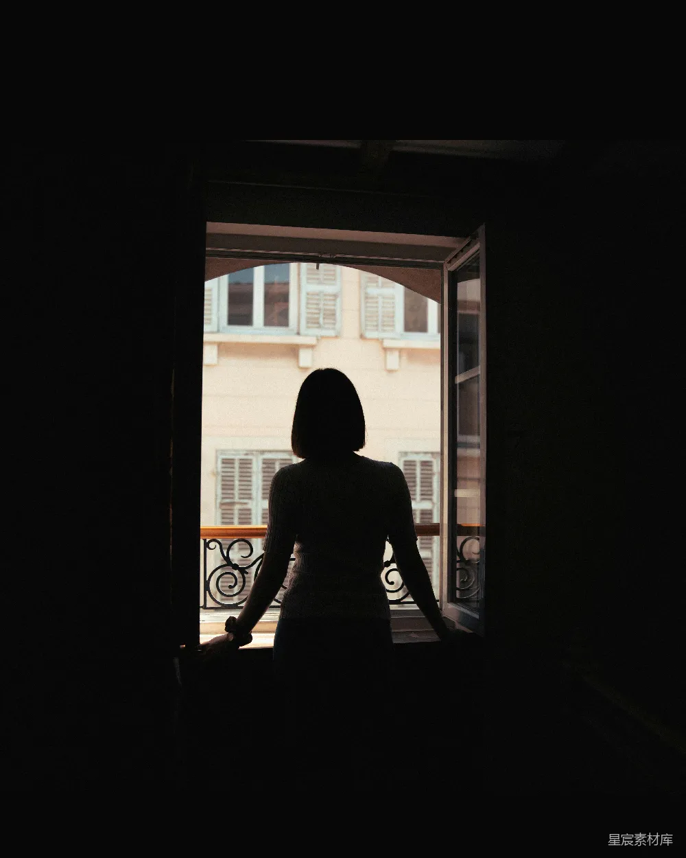 高清摄影  一个女人站在一扇敞开的门前。