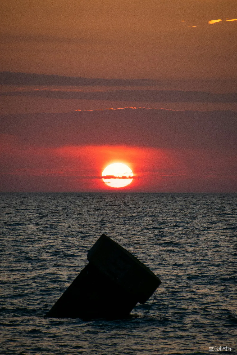夕阳西下，海面上一艘小船静卧水中。