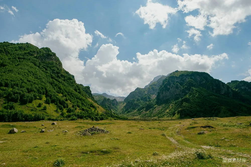 高清摄影 背景中有山的草坡场地