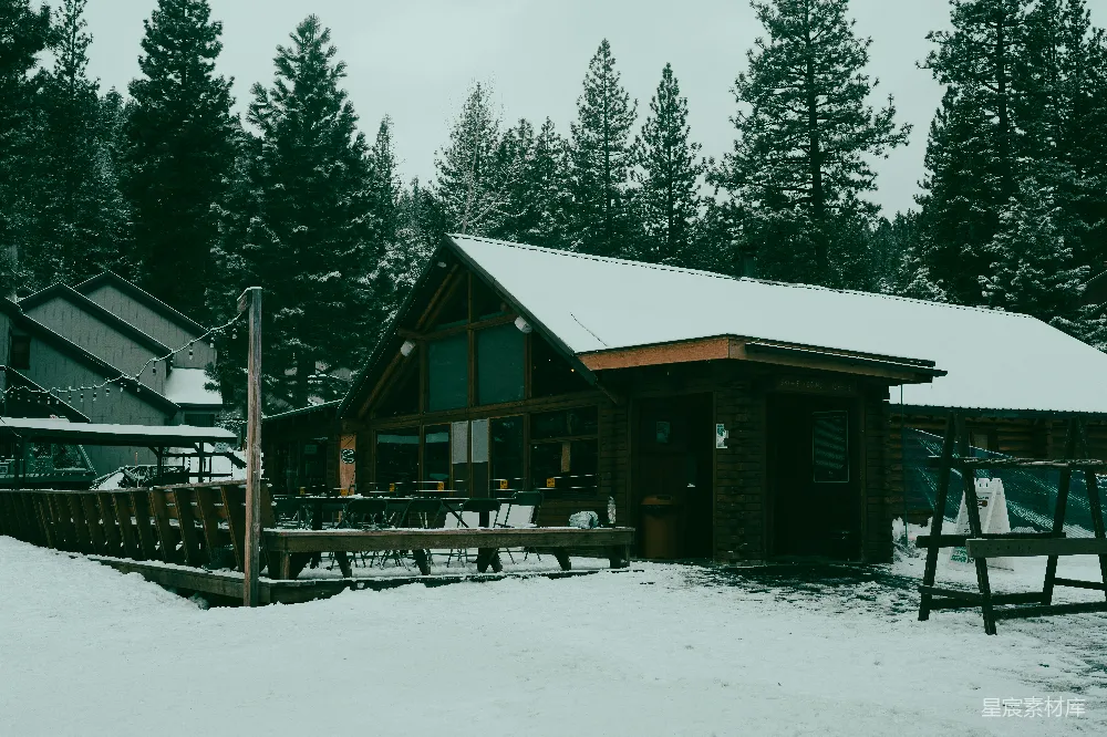 寒冷的一天，白雪覆盖的小屋周围是树木。