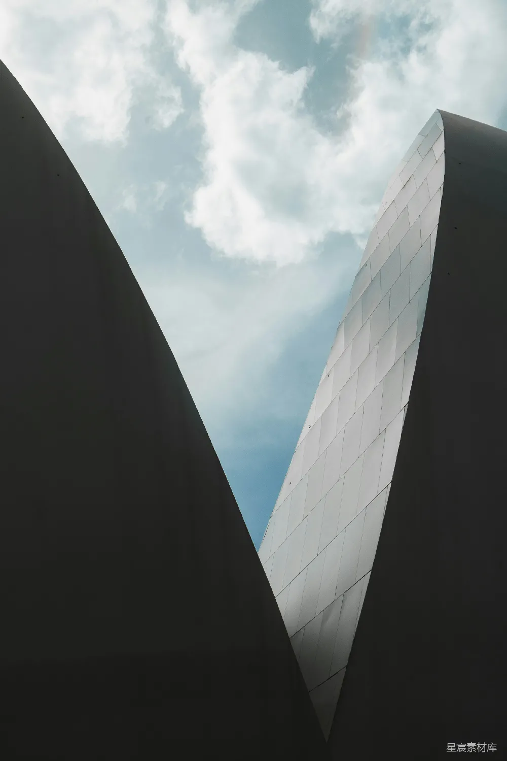 高清摄影  抽象的建筑曲线在多云的天空下。