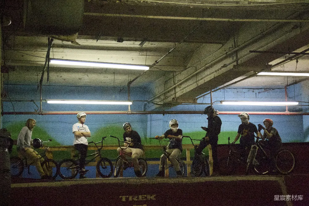 BMX骑行者们在室内滑板公园等待。