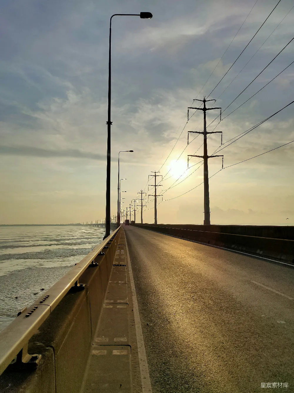 夕阳西下，落在路上的海面上。