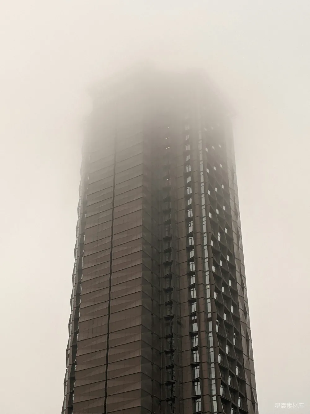 一栋高耸的建筑旁边有一座高大的钟表。