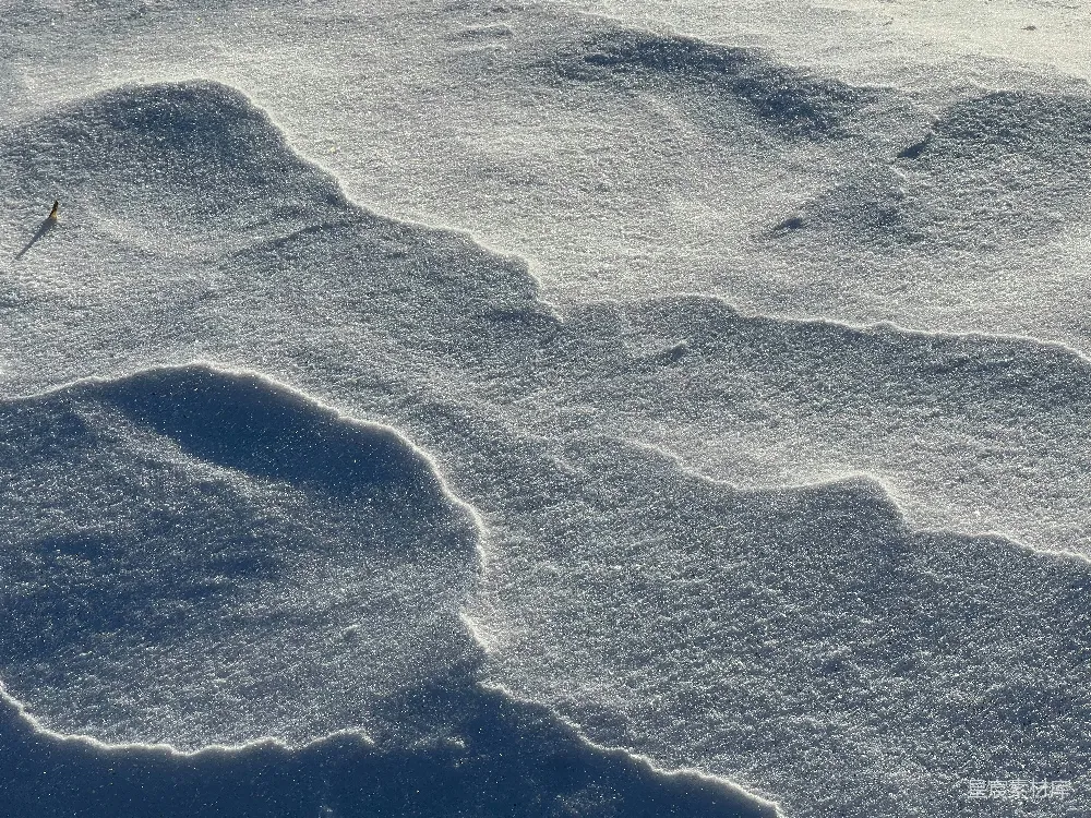 有纹理的雪堆映衬着阴影和高光