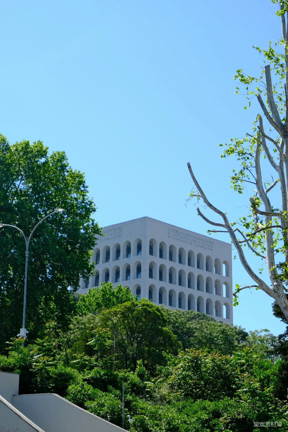 高清摄影  现代的白色建筑，带有拱形窗户，周围环绕着树木。