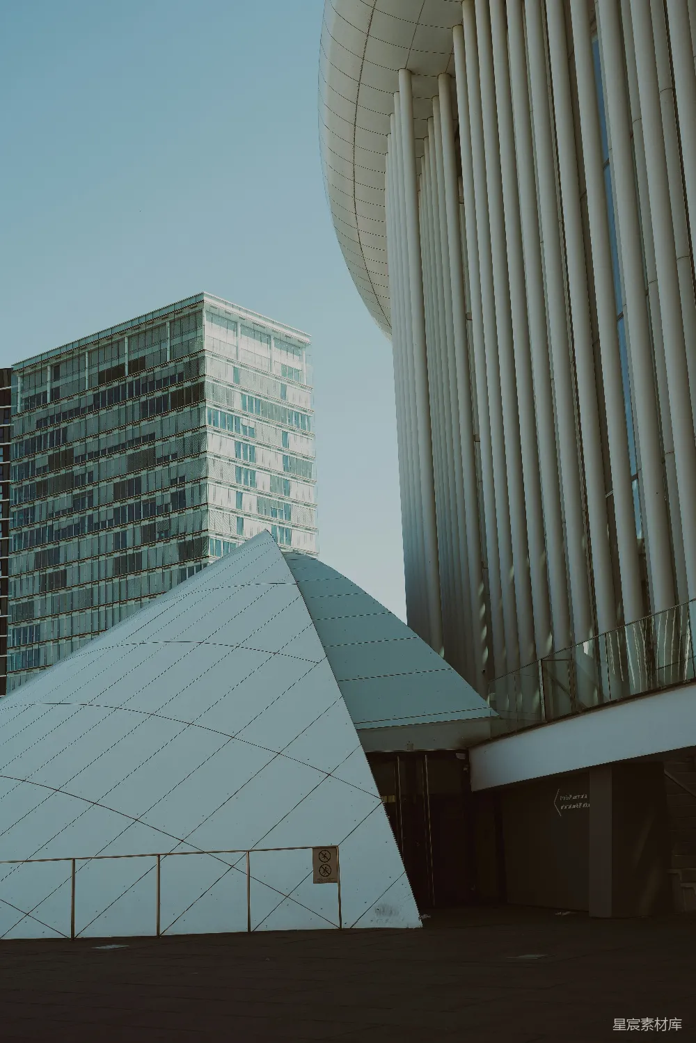 高清摄影  现代建筑，有一座高大的建筑和一个三角形结构。