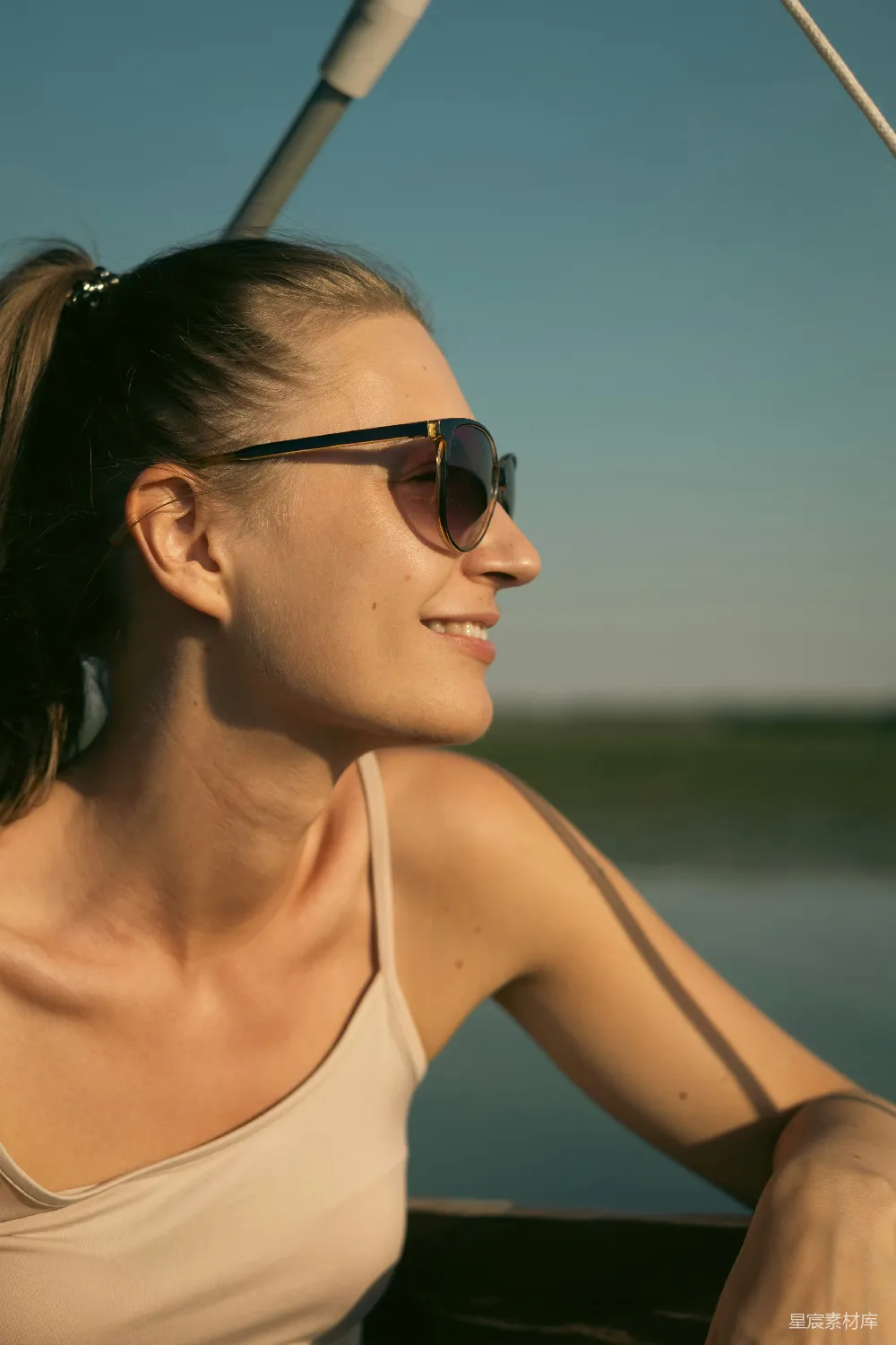 戴着太阳镜的女人正在一艘船的上坐着。