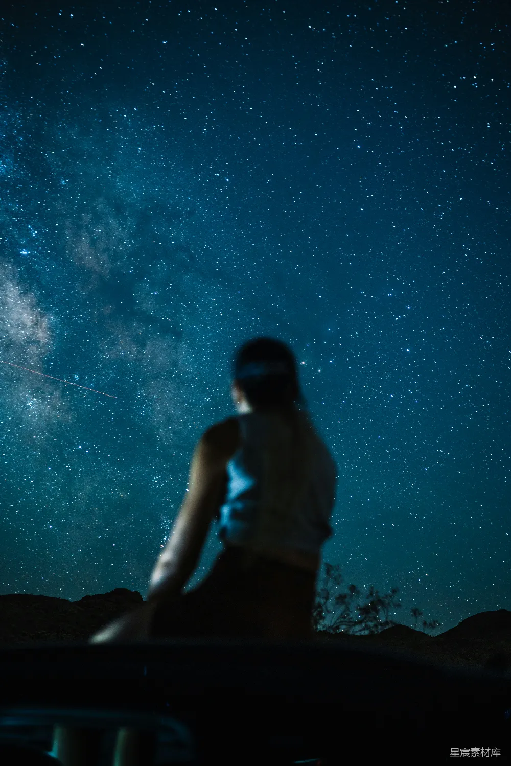 一个人在星光璀璨的夜空前站立
