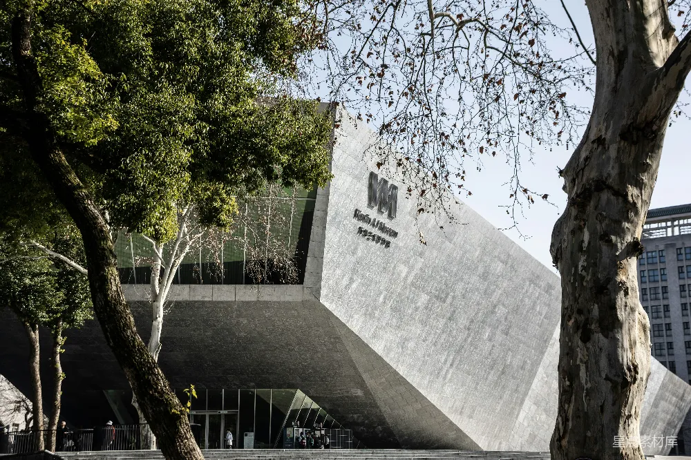 高清摄影  现代混凝土建筑，前景有树木。