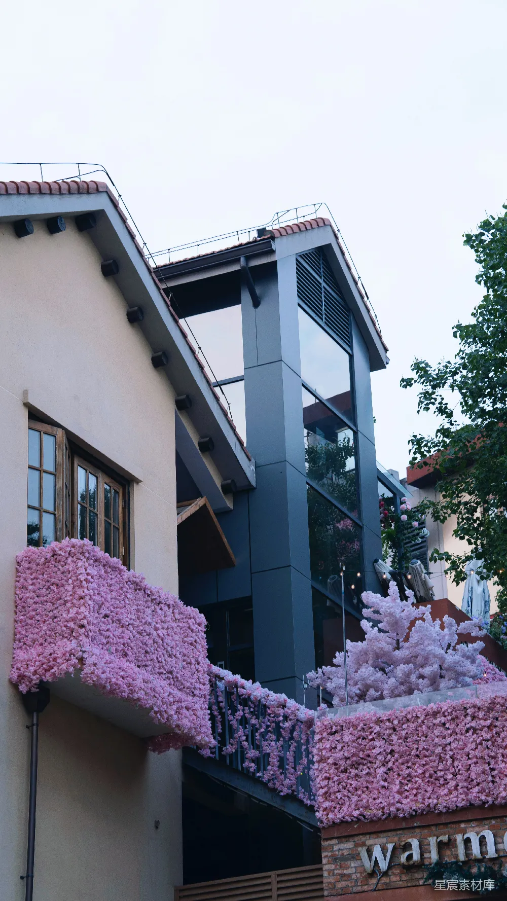 高清摄影  带有阳台和屋顶装饰着粉红色花卉装饰的建筑。