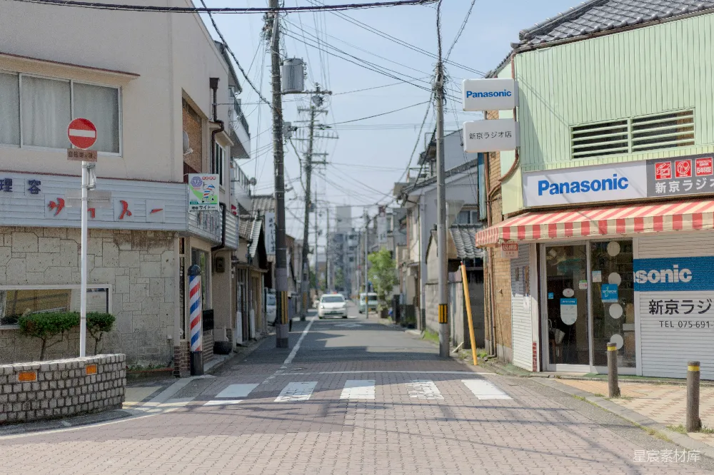 高清摄影  白色汽车在街上行驶，正接近十字路口。