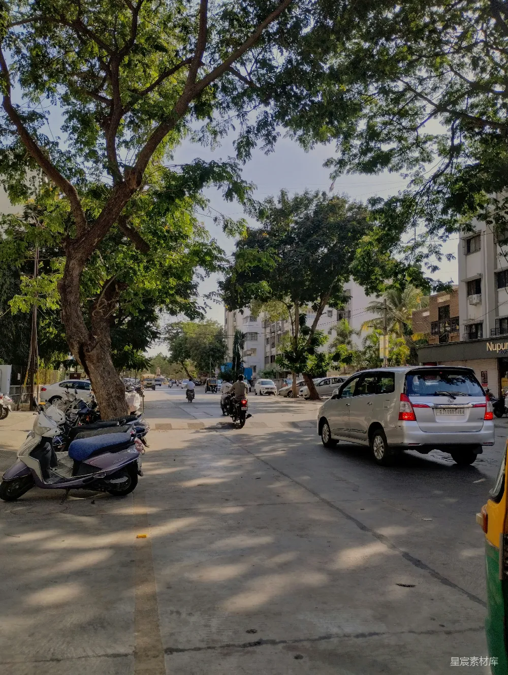 高清摄影 人物 旅行 自然 一辆摩托车停在道路旁边，树旁。
