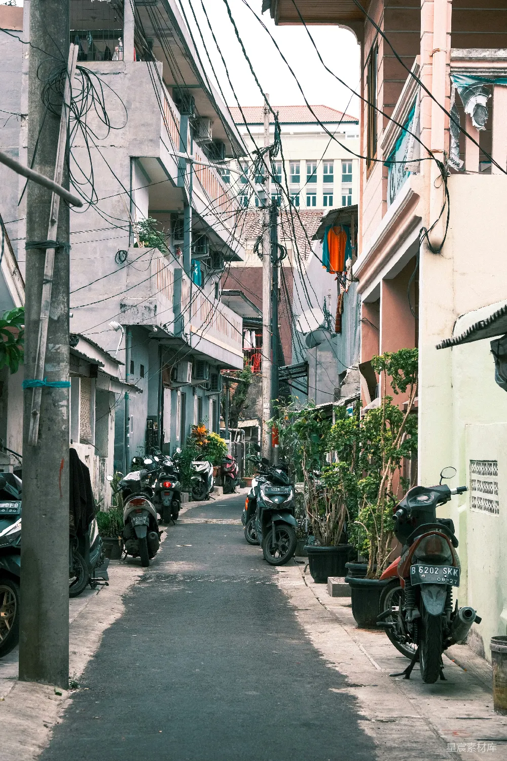 高清摄影  一条狭窄的城市街道，两旁停着摩托车。