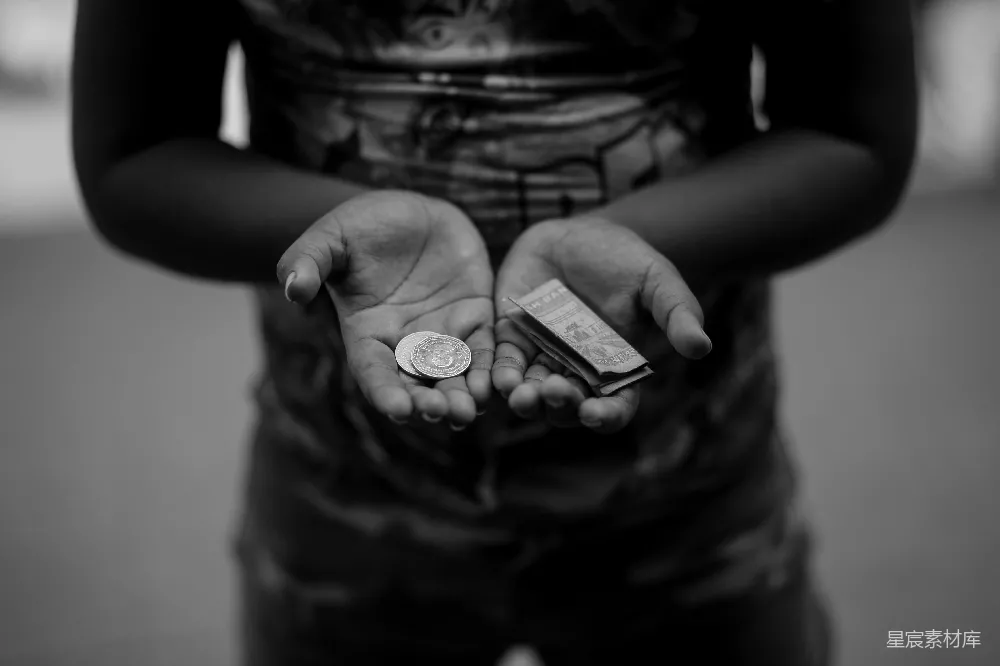 高清摄影  一张黑白照片，一个人手里拿着一枚硬币。