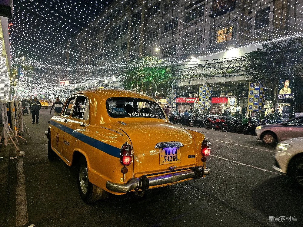 高清摄影  一辆黄色出租车沿着街道行驶，旁边停着几辆汽车。