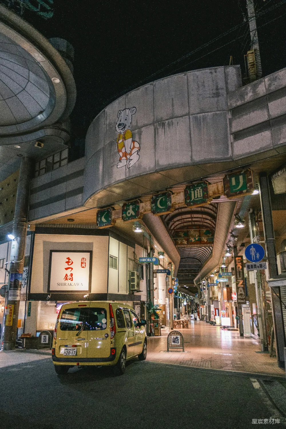高清摄影  一辆黄色的面包车停在一座建筑前。