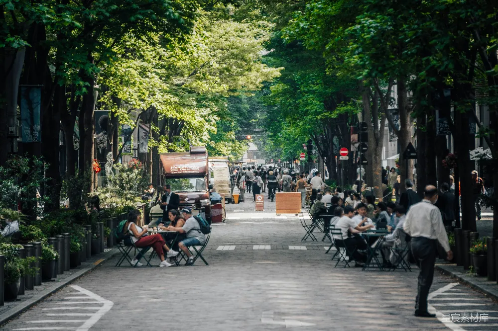 一群人在街道上坐着桌子用餐
