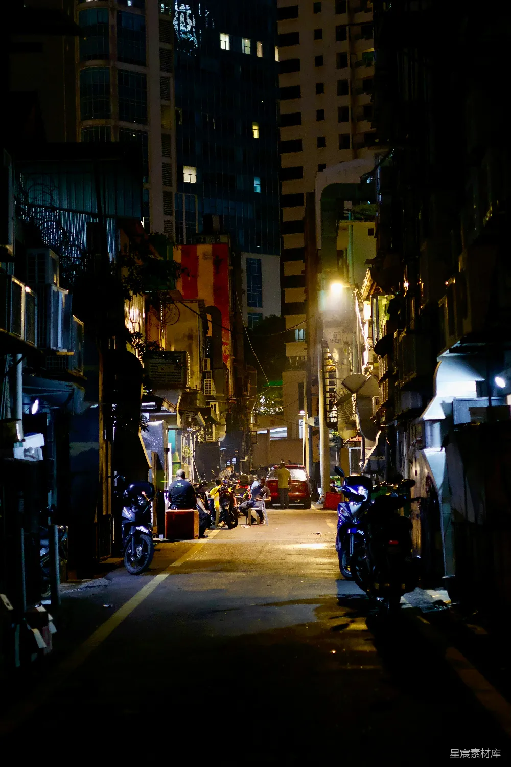 高清摄影  夜晚的一条城市街道，街道一侧停着摩托车。