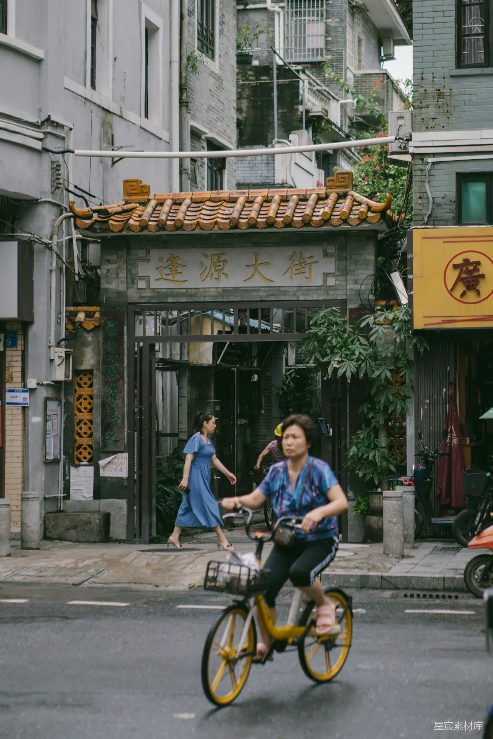 高清摄影 人物 一个男人骑着自行车，头上扛着一大捆木头。