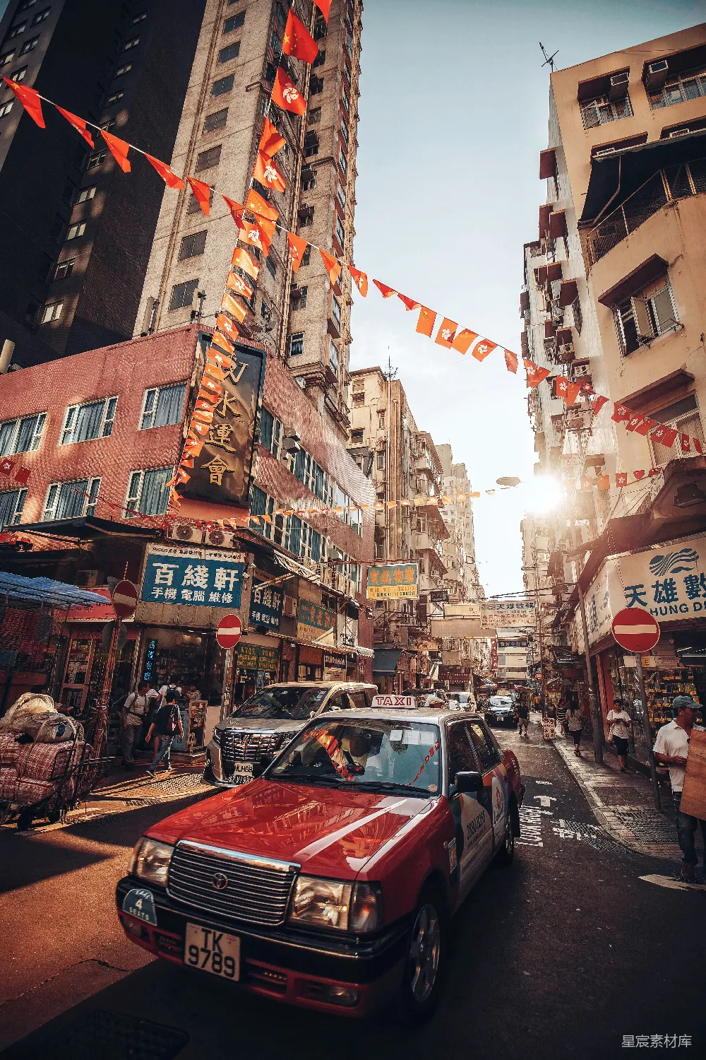 高清摄影  白天建筑物之间的路上行驶的汽车