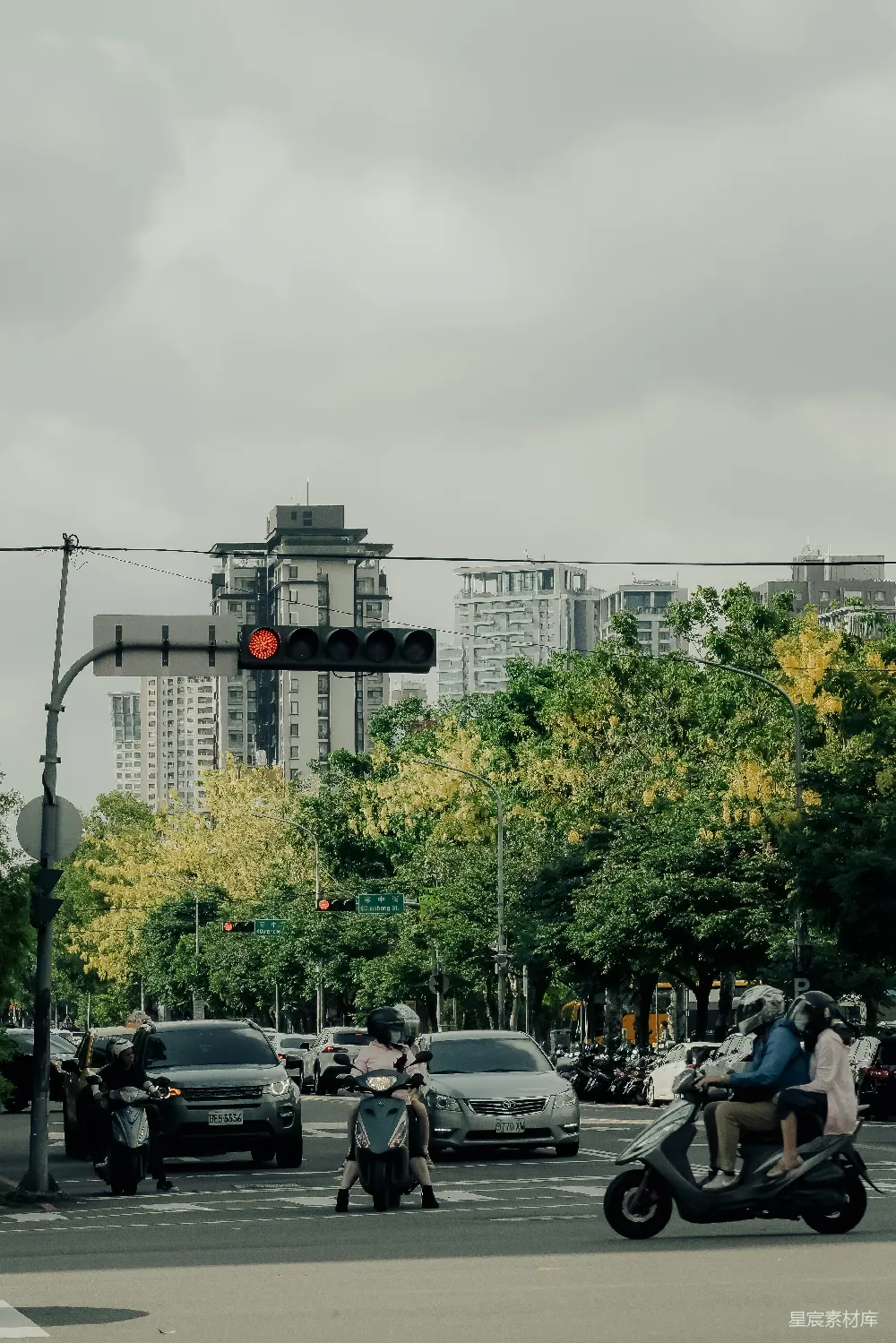高清摄影  摩托车和汽车在城市十字路口，有交通信号灯。