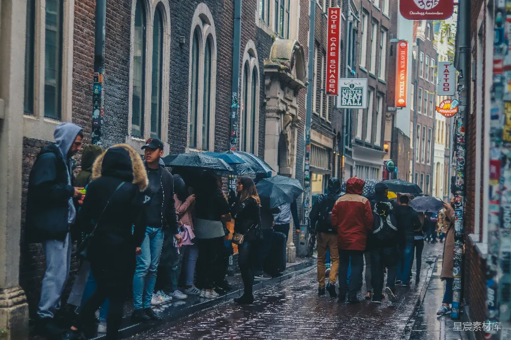 高清摄影  一群人带着雨伞站在人行道上