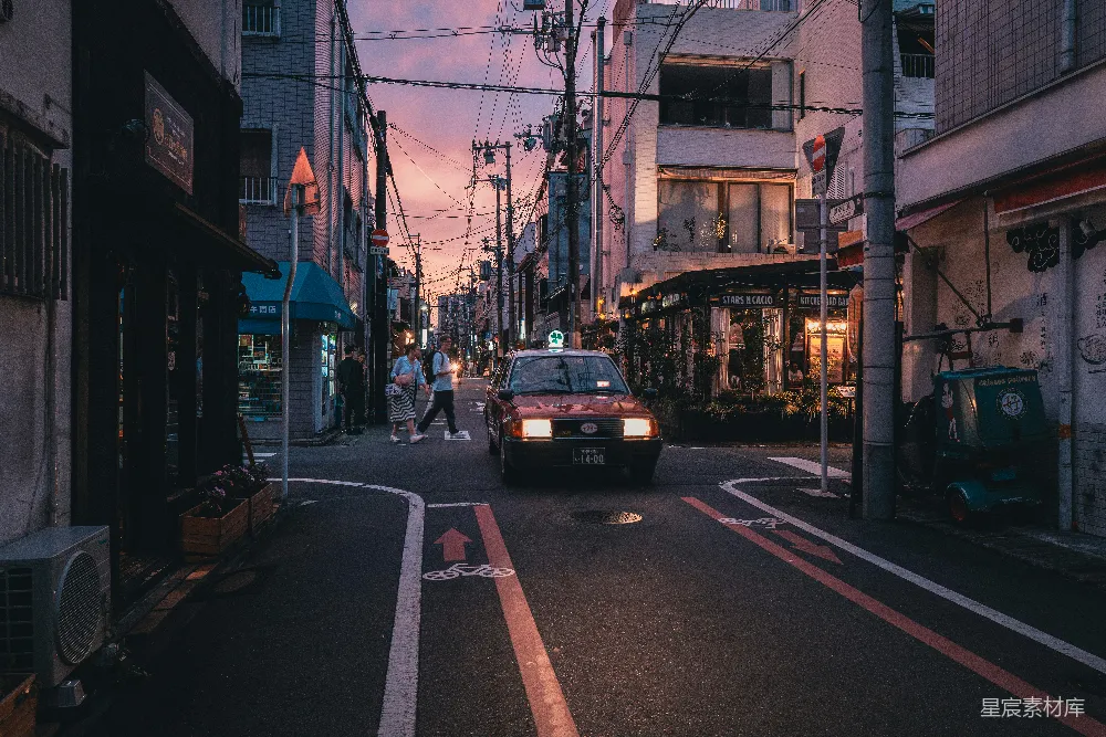 高清摄影  一辆汽车沿着一条街道行驶，两旁是高楼大厦。