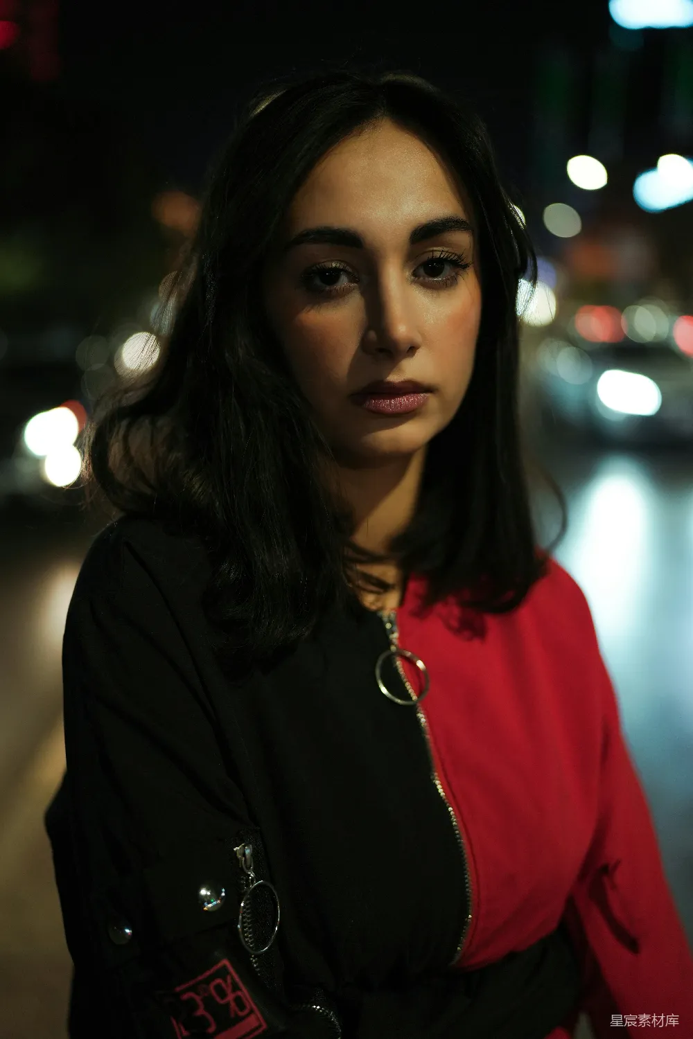 身穿红黑夹克的女人在夜晚
