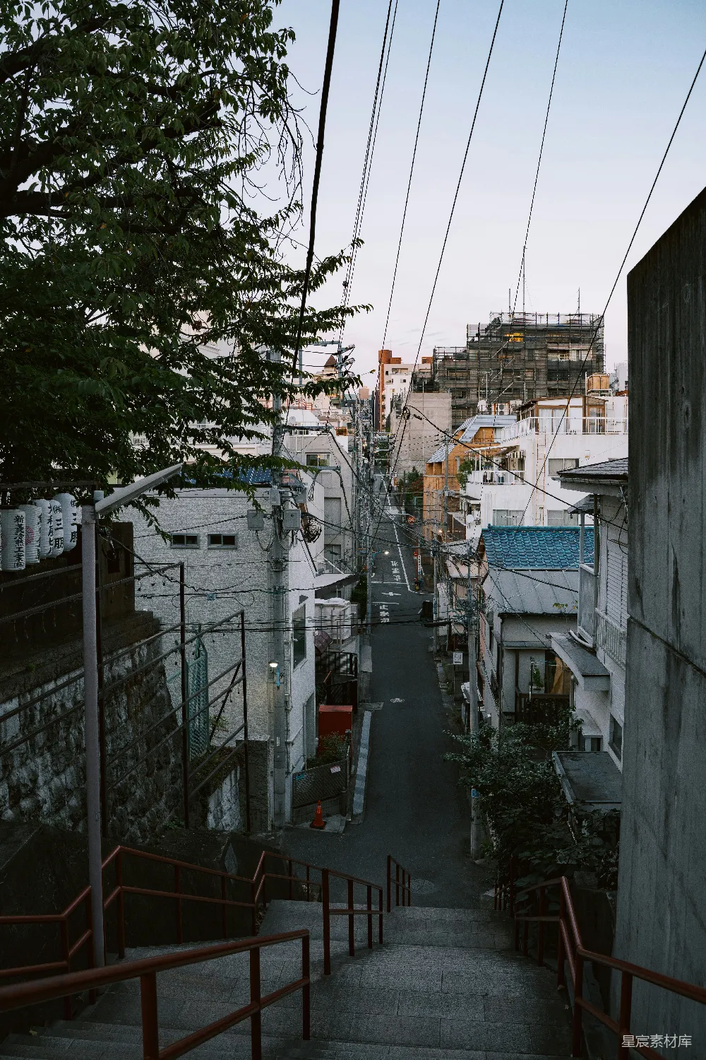 高清摄影  一条陡峭的街道两旁是房屋和电线。