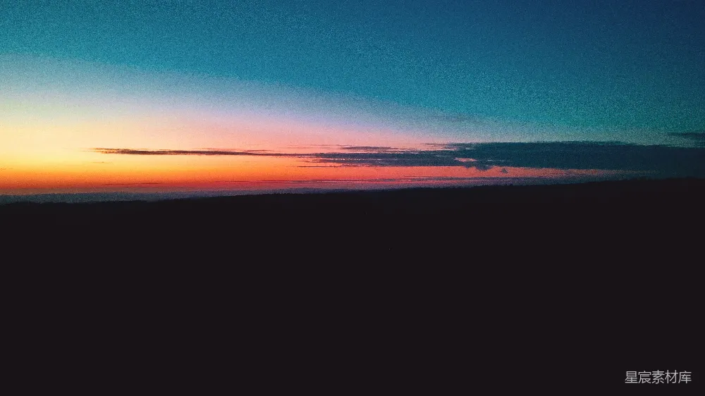 一幅绚丽的夕阳映衬在黑暗背景中的画面。