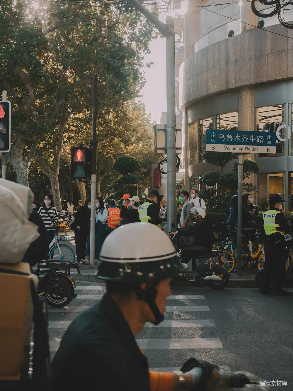 高清摄影  一个男人骑自行车沿着街道经过一个交通灯。