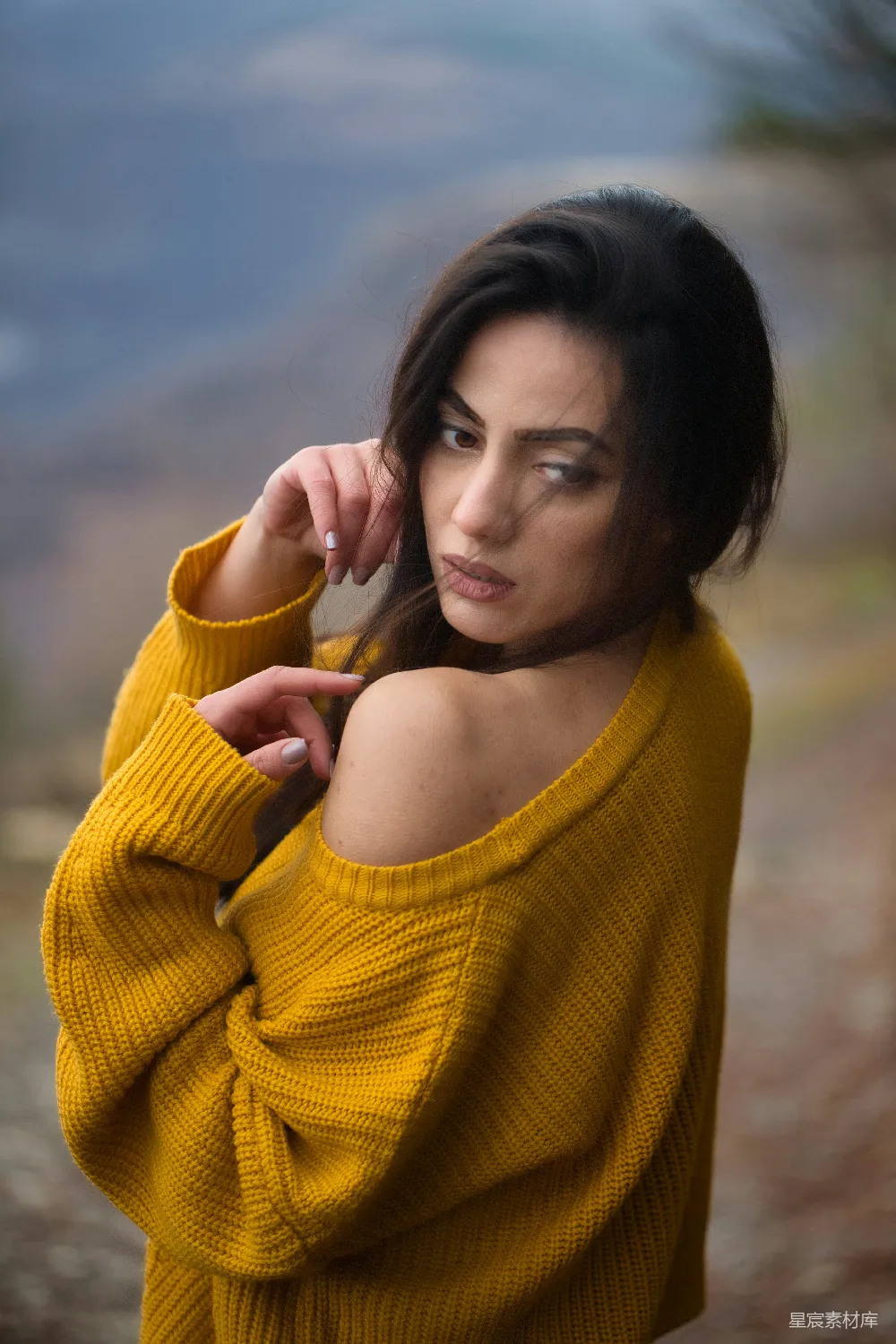 一个穿着黄色毛衣的女人在拍照。