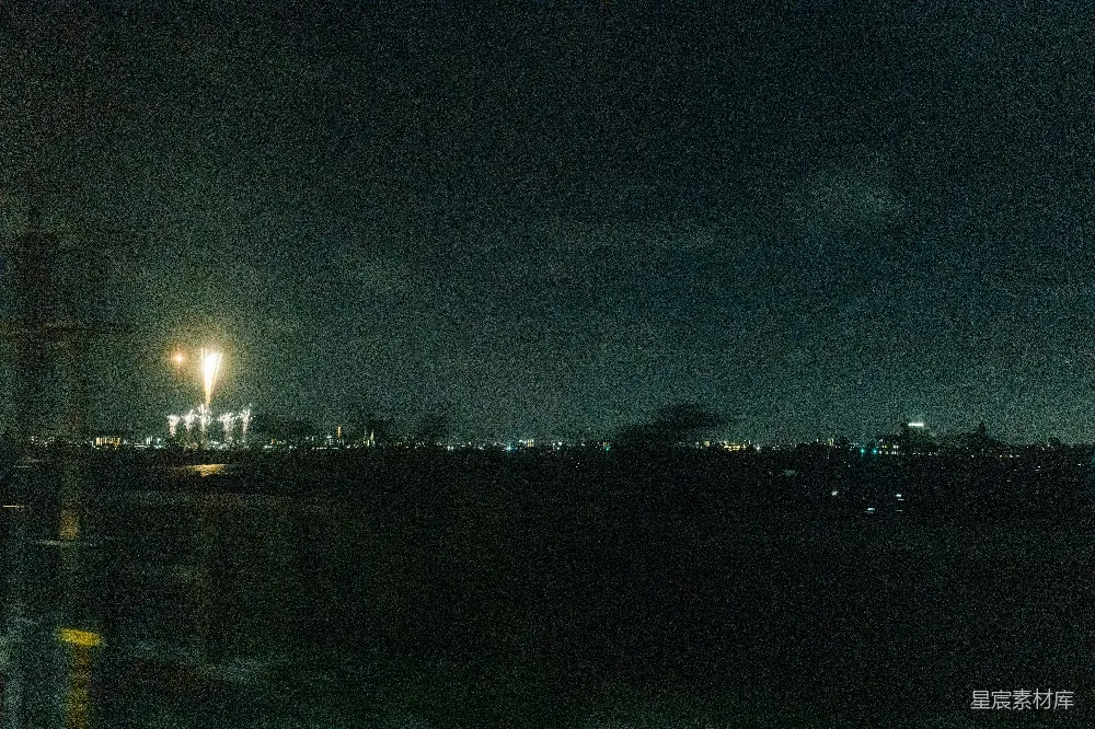 夜晚，烟花在遥远城市 skyline 上绽放。