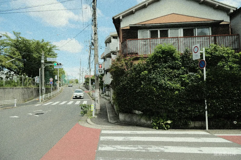 高清摄影  一辆汽车沿着街道行驶，旁边有一座高楼。