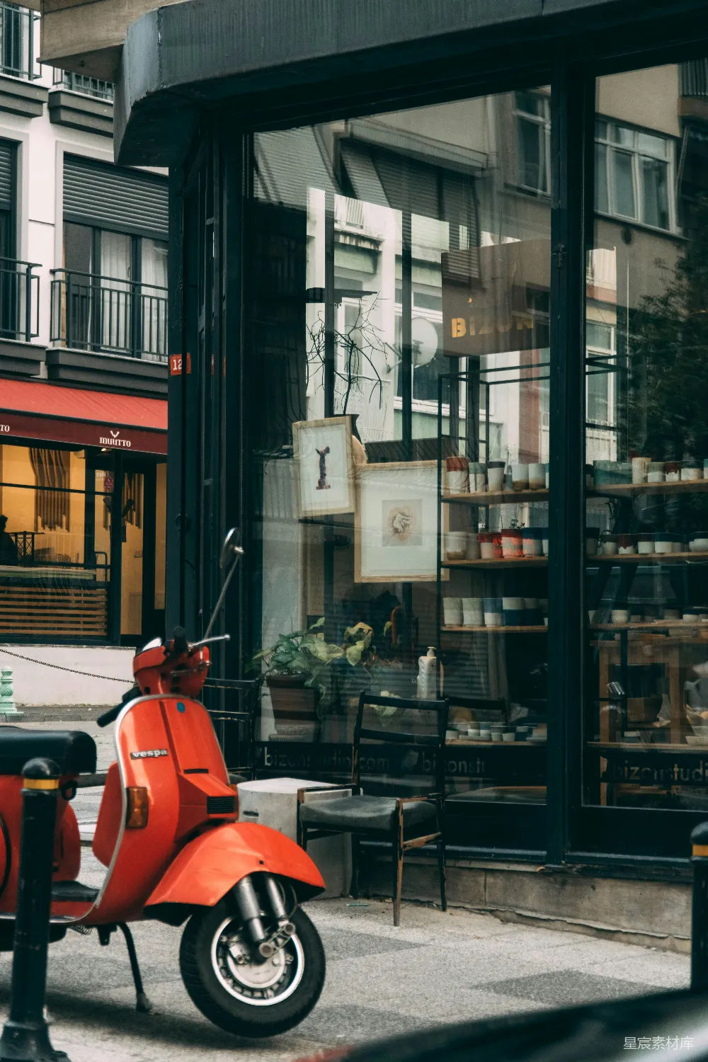 高清摄影  穿红衬衫的男人坐在商店附近的红色椅子上，白天。