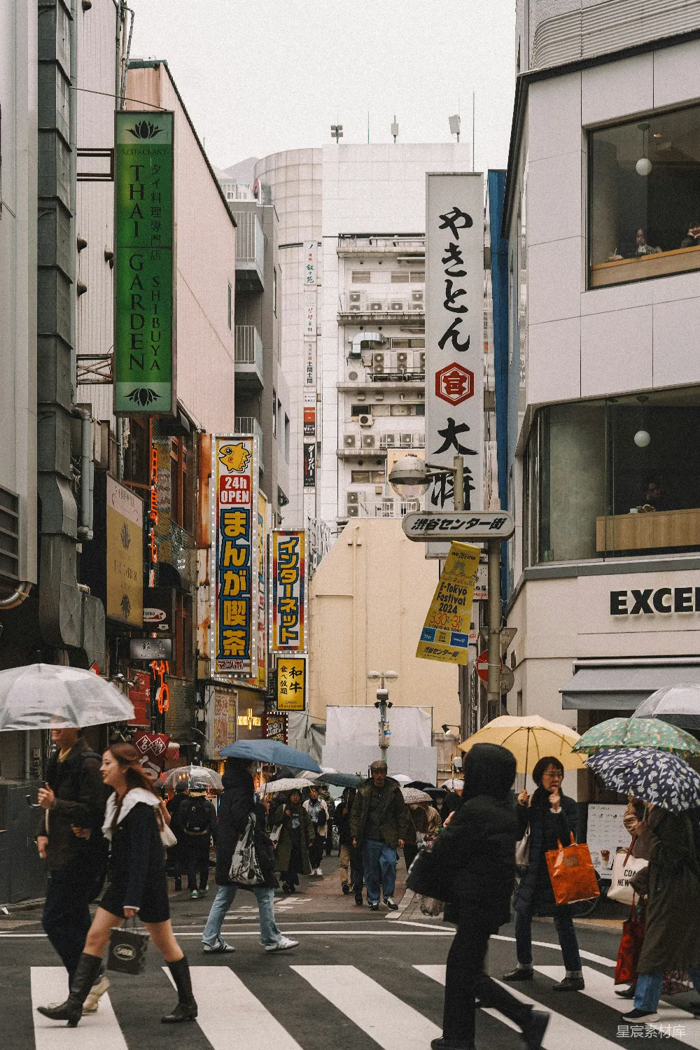 高清摄影 旅行 一群人在街道上行走，手中拿着雨伞。