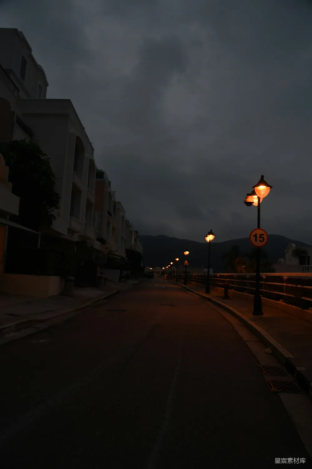 高清摄影  路灯在黄昏时分照亮了空荡荡的黑暗道路。