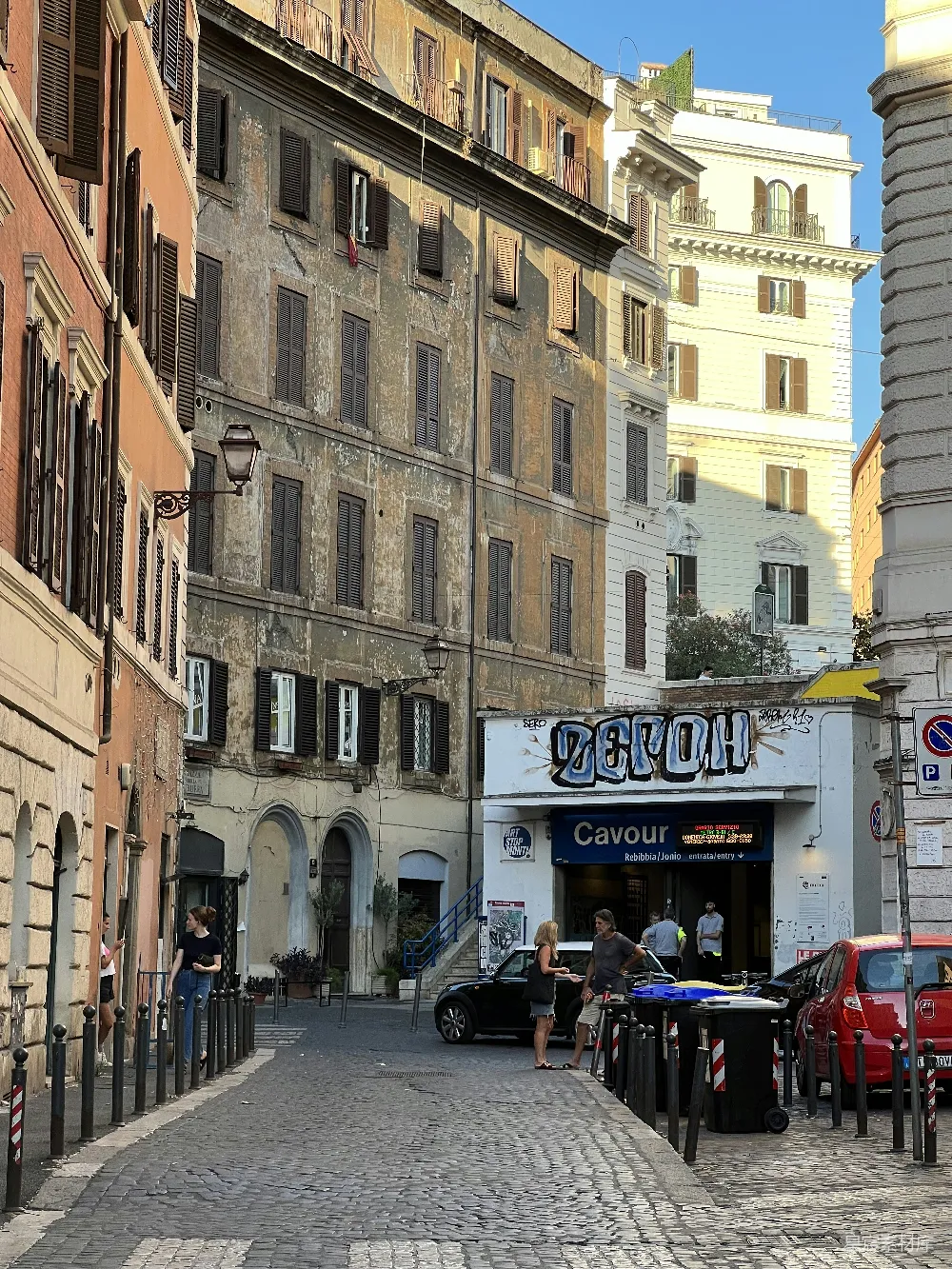 高清摄影 旅行 一群人坐在建筑物前的桌子旁。
